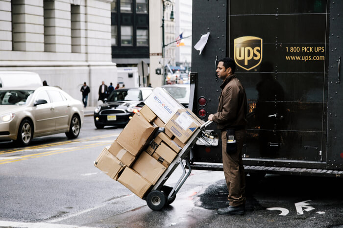 UPS Bote vor Paketauto mit Paketen