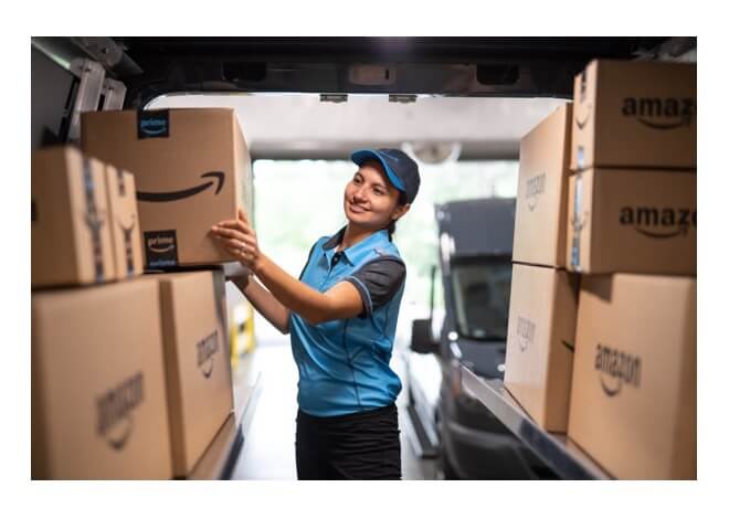 Amazon Logistiks Paketbotin im Lieferwagen