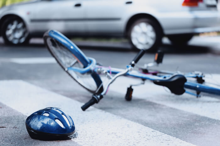 Fahrrad und Helm liegen auf der Straße.