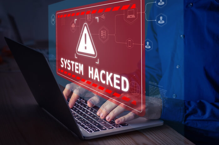 Person am Laptop hat sich in sein System gehackt Warnmeldung