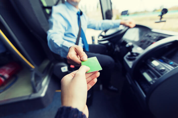 Busfahrer nimmt Fahrkarte von Passagier