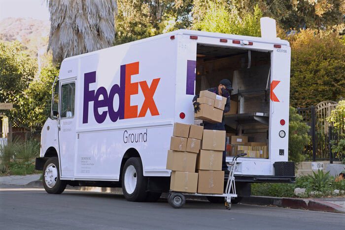 FedEx-Fahrer beim Verladen von Paketen in Lieferwagen