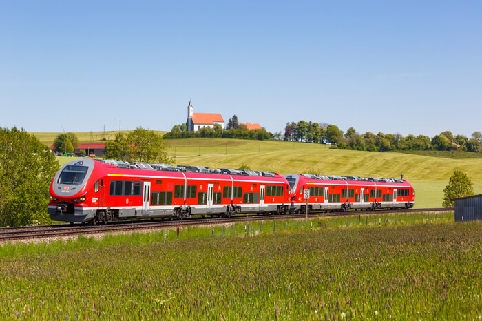 Regionalzug Nahverkehr Deutsche Bahn fährt durch Landschaft
