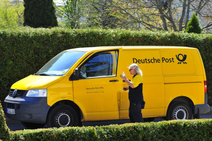 Zustellerin und Lieferfahrzeug der Deutschen Post