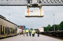 DPD Team und Container neben Güterzug