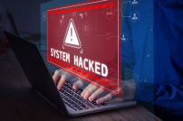 Person am Laptop hackt sich in ein System Warnmeldung